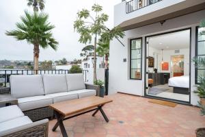 a living room with a couch and a table on a balcony at North Beach Villa in San Clemente