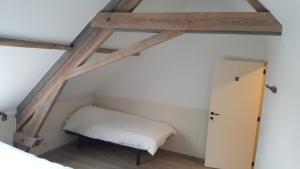 a small room with a bed and a ladder at vakantiewoning onZENhof in Heuvelland