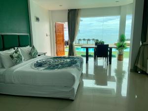 a bedroom with a bed and a table with a view at 4U Resort Samui in Lamai