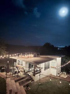 une maison avec des lumières sur le toit la nuit dans l'établissement Swansea Hills Tiny Home, à Puerto Princesa