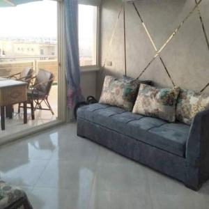 a living room with a blue couch and a table at الاسكندريه المعموره الشاطئ in Alexandria
