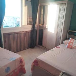 a hotel room with two beds and a window at الاسكندريه المعموره الشاطئ in Alexandria