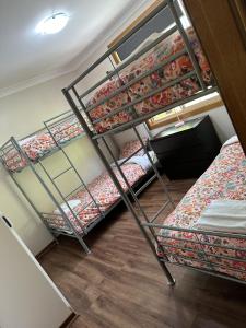 a room with three bunk beds in a room at Chiltern Lodge Country Retreat in Old Bar