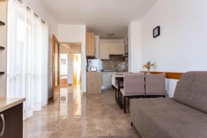 een woonkamer en een keuken met een bank en een tafel bij Holiday home Milka - in center & close to the sea in Sali