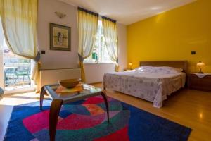 a bedroom with a bed and a coffee table and a window at Apartments Villa Katarina in Selce
