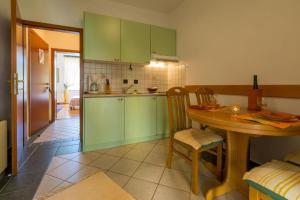 a kitchen with green cabinets and a wooden table at Apartments Villa Katarina in Selce