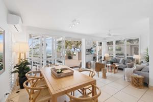 a living room with a table and chairs at Portofino 1 in Noosa Heads