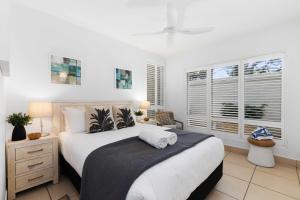 una camera da letto con un grande letto con una coperta nera di Portofino 1 - Beachfront Apartment Noosa Heads a Noosa Heads Altre 18 foto