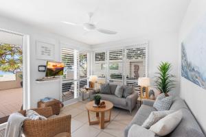 a living room with two couches and a table at Portofino 1 in Noosa Heads