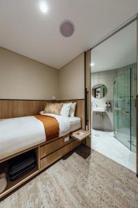1 dormitorio con 1 cama y ducha acristalada en Aerotel Sydney (Arrivals B, International Terminal 1) en Sídney