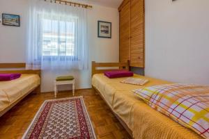 a bedroom with two beds and a window at Apartments Vlasta in Dramalj