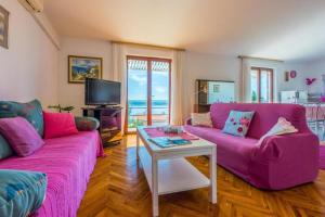a living room with two purple couches and a table at Apartments Vlasta in Dramalj