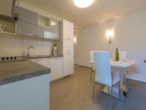 a kitchen with a table and some white cabinets at Apartments Jadranka in Dramalj