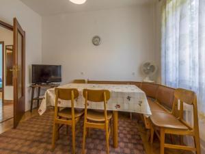 a dining room with a table and chairs and a television at Apartments Tara in Selce