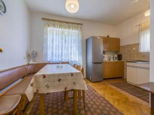 a kitchen with a table and a stainless steel refrigerator at Apartments Tara in Selce