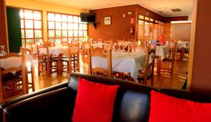 Ontígola的住宿－帕拉達酒店，用餐室配有桌椅和红色枕头