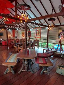 a restaurant with wooden tables and benches in a room at Harley Moon Hideaway in Ko Chang