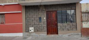 eine rote Tür an der Seite eines Gebäudes in der Unterkunft Violeta Dulce Hospedaje Familiar Privado en PACASMAYO in Pacasmayo