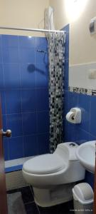 a blue tiled bathroom with a toilet and a sink at Violeta Dulce Hospedaje Familiar Privado en PACASMAYO in Pacasmayo