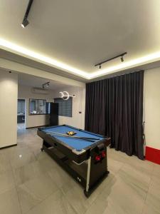 una habitación con una mesa de ping pong en el medio en 5000 SQFT BRAND NEW Semi-D Hype Home 10pax en Ipoh
