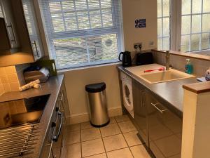 a kitchen with a sink and a washing machine at Southover Beach in Woolacombe +37 photos