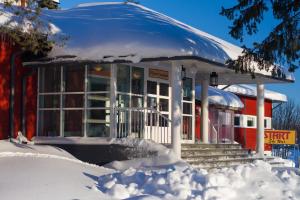 een gebouw bedekt met sneeuw met sneeuw eromheen bij Ylläs Lake Hotel in Ylläsjärvi