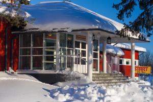 um edifício coberto de neve com neve à sua volta em Ylläs Lake Hotel em Ylläsjärvi