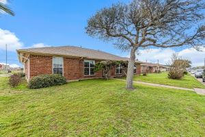 a brick house with a tree in the yard at Dolphin Lodge in Galveston