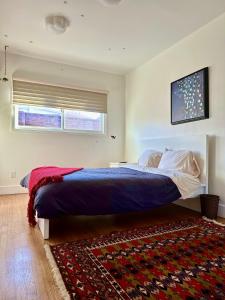 a bedroom with a large bed and a rug at Venice Beach Bungalow in Los Angeles