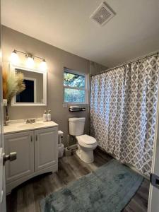 Un baño con lavabo, inodoro y ventana. en Spacious/Cozy home in Fort Worth, en Fort Worth