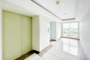 Zimmer mit grünen und weißen Wänden und einem großen Fenster in der Unterkunft RedLiving Apartemen Green Lake View Ciputat - Pelangi Rooms 1 Tower E in Pondokcabe Hilir