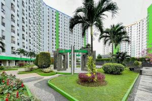 ein großes Gebäude mit Palmen im Innenhof in der Unterkunft RedLiving Apartemen Green Lake View Ciputat - Pelangi Rooms 1 Tower E in Pondokcabe Hilir