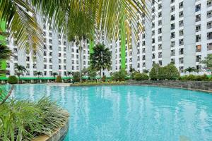 una gran piscina frente a un gran edificio en RedLiving Apartemen Green Lake View Ciputat - Pelangi Rooms 1 Tower E, en Pondokcabe Hilir