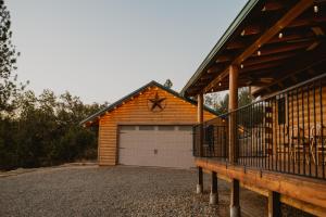 a house with a garage door and a porch at Yosemite Charm by Casa Oso with spa and breathtaking views in Mariposa