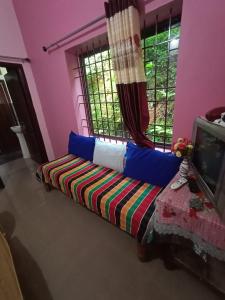 een woonkamer met een bank en een tv bij Nakshatra Homestay in Madikeri