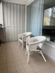 2 Stühle und ein Tisch auf dem Balkon in der Unterkunft Huoneisto Jalkarannassa in Lahti