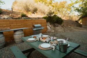 stół piknikowy z talerzami jedzenia i grillem w obiekcie Yosemite Charm by Casa Oso with spa and breathtaking views w mieście Mariposa