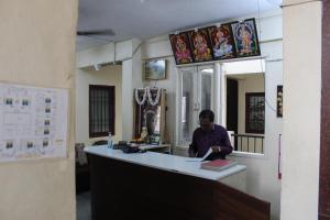 un hombre sentado en un mostrador en una habitación en Agp Homestay en Chennai