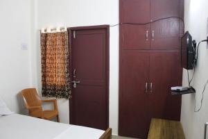 Habitación con armario, puerta y silla en Agp Homestay en Chennai