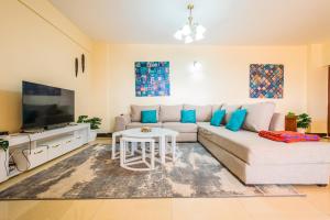 a living room with a couch and a tv at Art-inspired 3BR Apartment in Nairobi