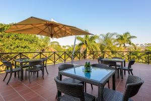 a patio with tables and chairs and an umbrella at San Lameer Villa 3014 - 3 Bedroom Classic - 6 pax - San Lameer Rental Agency in Southbroom