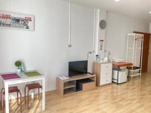 a living room with a desk and a tv and a table at Na cha lae 2 in Chanthaburi