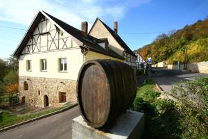 a large wooden barrel sitting in front of a building at Ferienwohnung Weingut Kloster Pforta in Naumburg