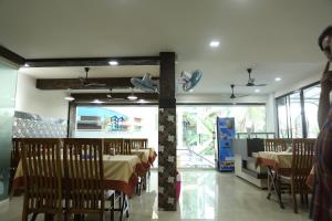 un ristorante con tavoli e sedie in una stanza di Kay Pee's Grande a Cochin