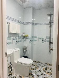 biała łazienka z toaletą i prysznicem w obiekcie Motel Hoa Hồng w mieście Vung Tau