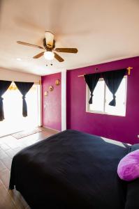 Villas del Sol في Ipala: غرفة نوم بسرير أسود وجدران أرجوانية