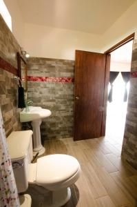 a bathroom with a white toilet and a sink at Villas del Sol in Ipala