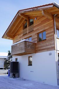 a wooden house with a balcony on top of it at Ferienwohnung Eckmair in Schliersee