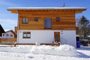 a house with snow in front of it at Ferienwohnung Eckmair in Schliersee