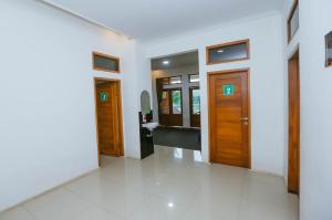 - un couloir dans un bâtiment avec des portes en bois dans l'établissement De Bloem Lake View Pangalengan, à Pengalongan
